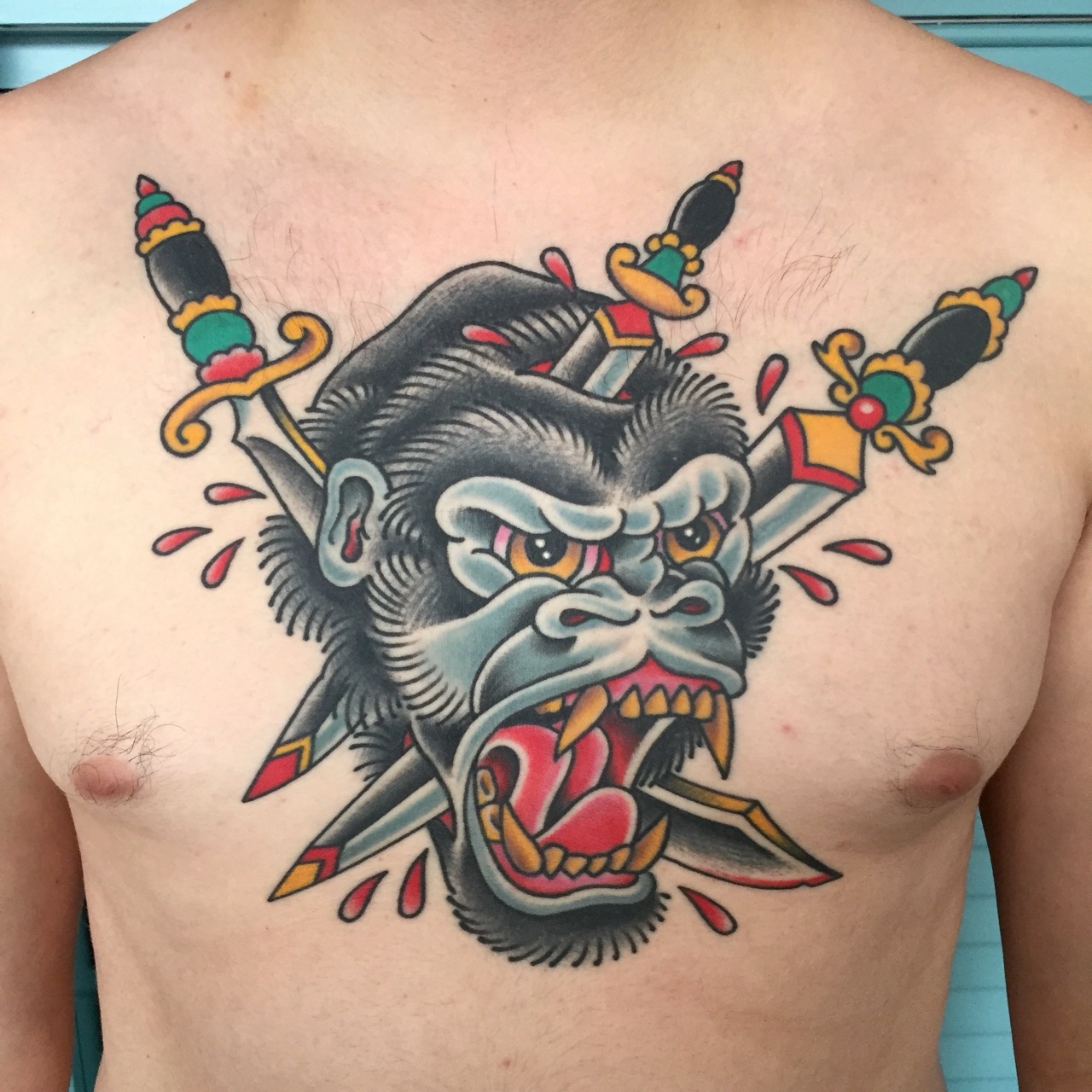 Healed traditional gorilla and daggers chest tattoo